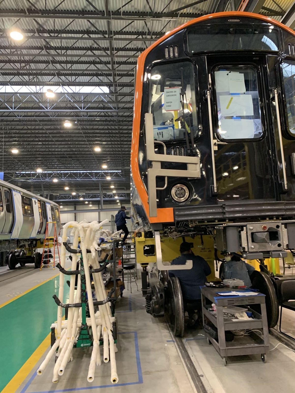 Technicians supporting installation on a car at the assembly plant
